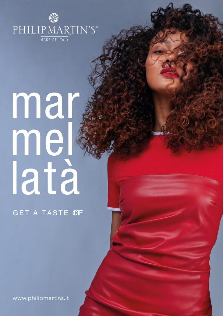 Advertisement poster for Philip Martin's featuring a woman with curly hair in a red satin dress set against a blue backdrop, with bold white vertical text on the left side.