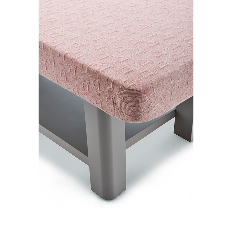 2-1png โ Rapple Pink textured upholstered ottoman with a rounded corner and gray legs on a light floor.