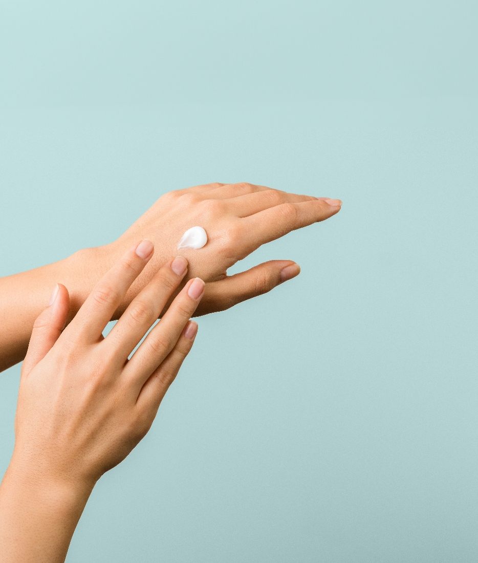 Hands smoothing in a dab of AVRA cream