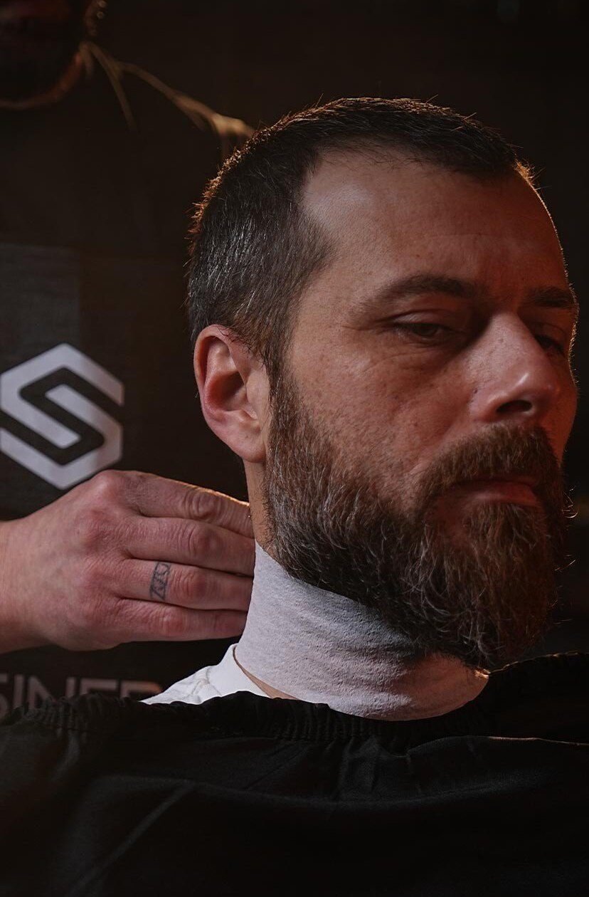 Client with a neck strip in the barber chair