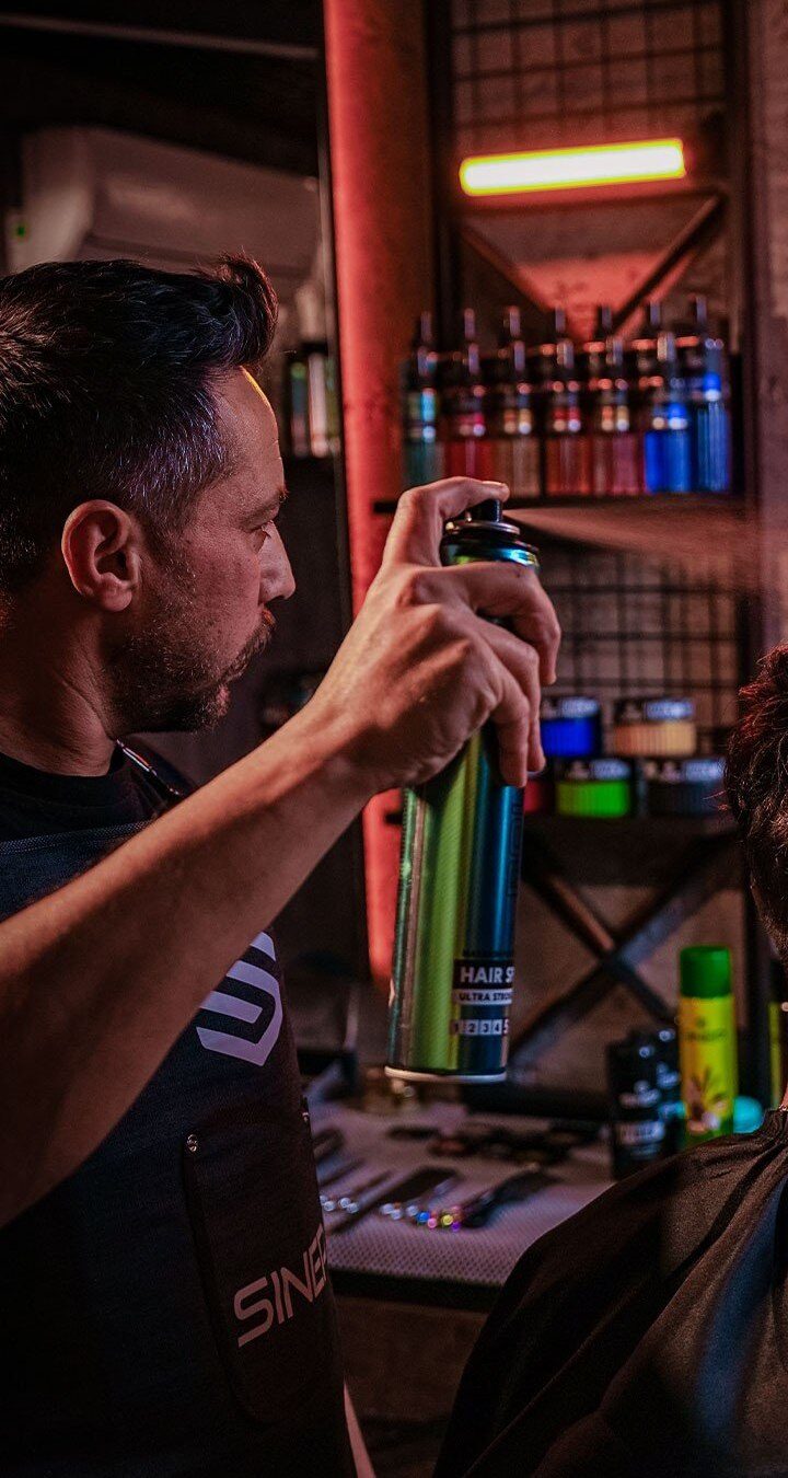 Barber finishing a style with SINEP hair spray