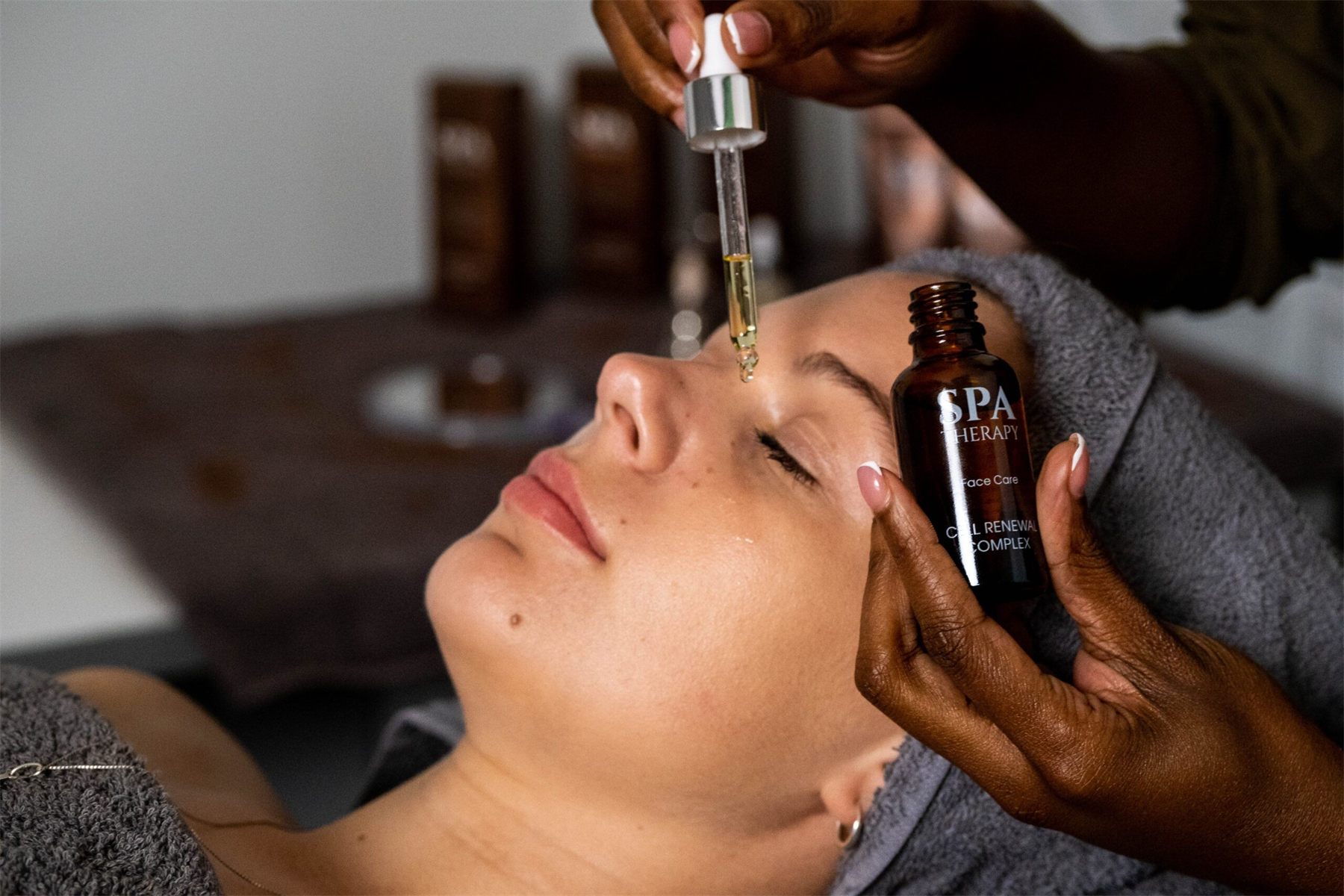 Therapist applying Spa Therapy serum during a facial