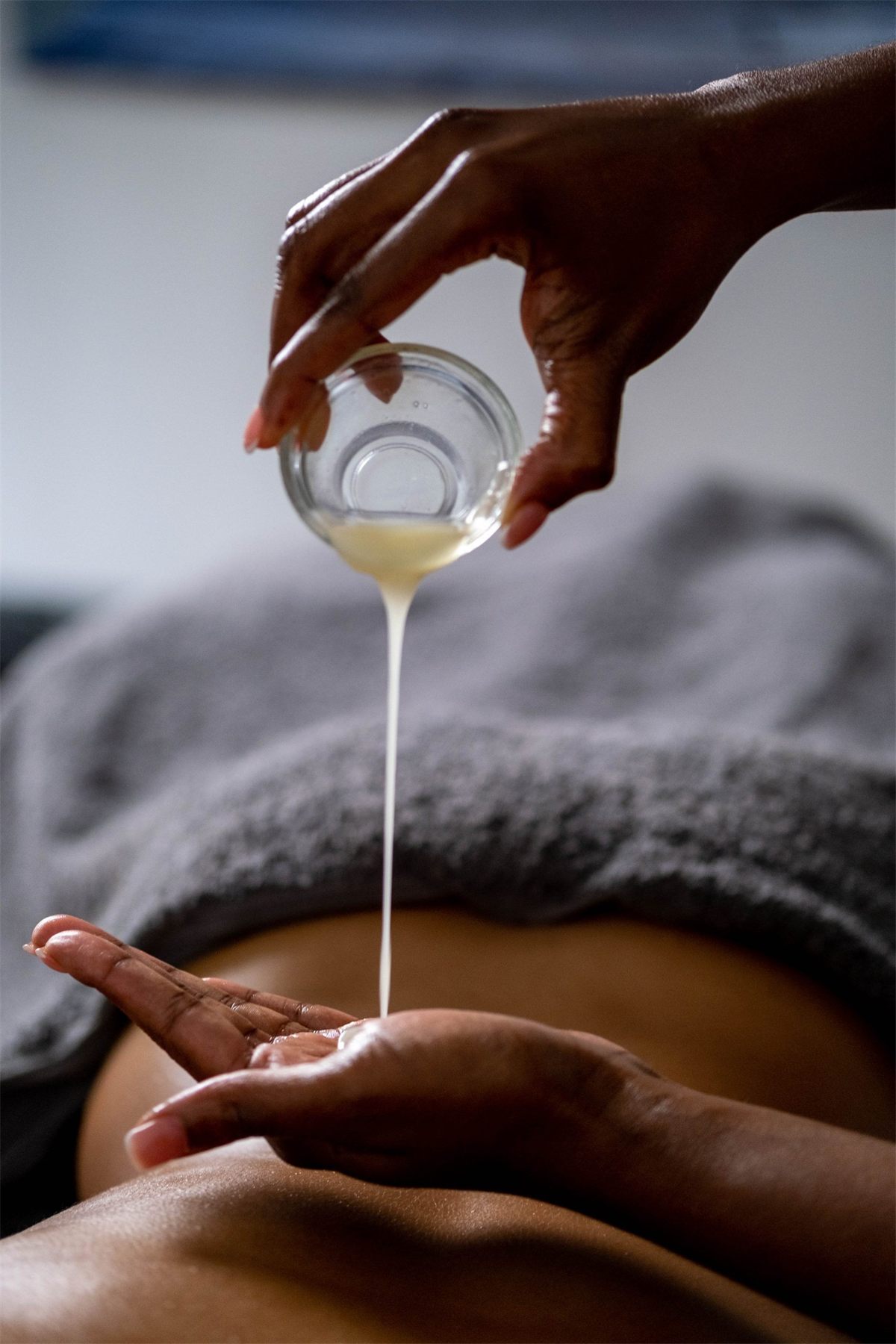 Warm oil poured into a therapist's hand