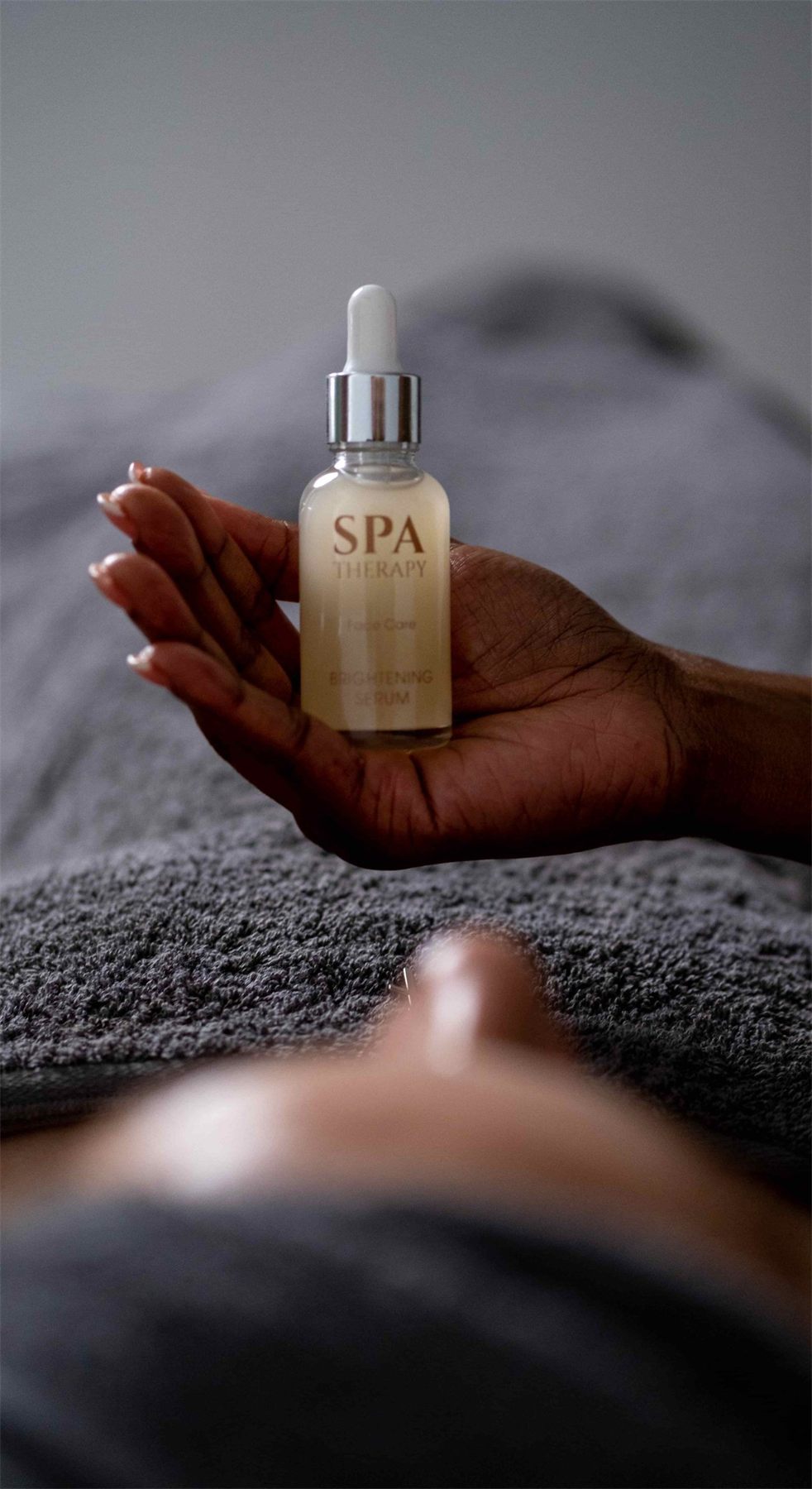 Spa Therapy serum held in a hand